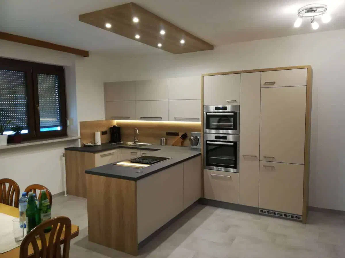 Küche in Creme und Holz mit Deckenpaneel