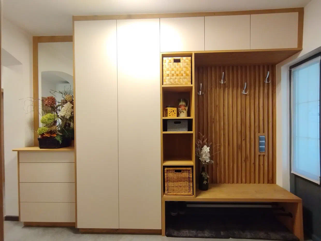 Cremeweiße Einbaugarderobe mit Holznische, Sitzbank und Spiegel im Vorzimmer