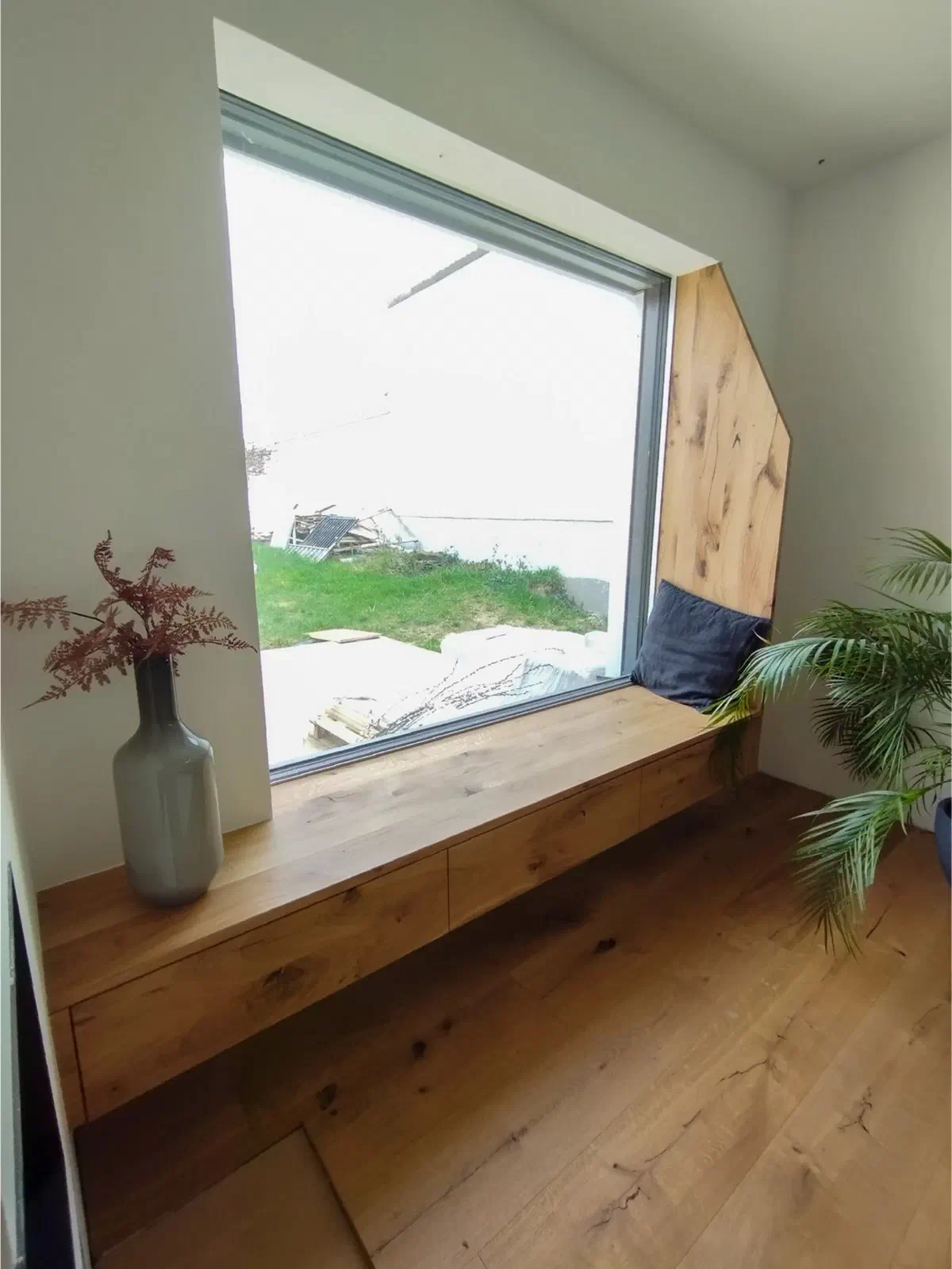 Sitzfenster aus Holz mit Pflanze