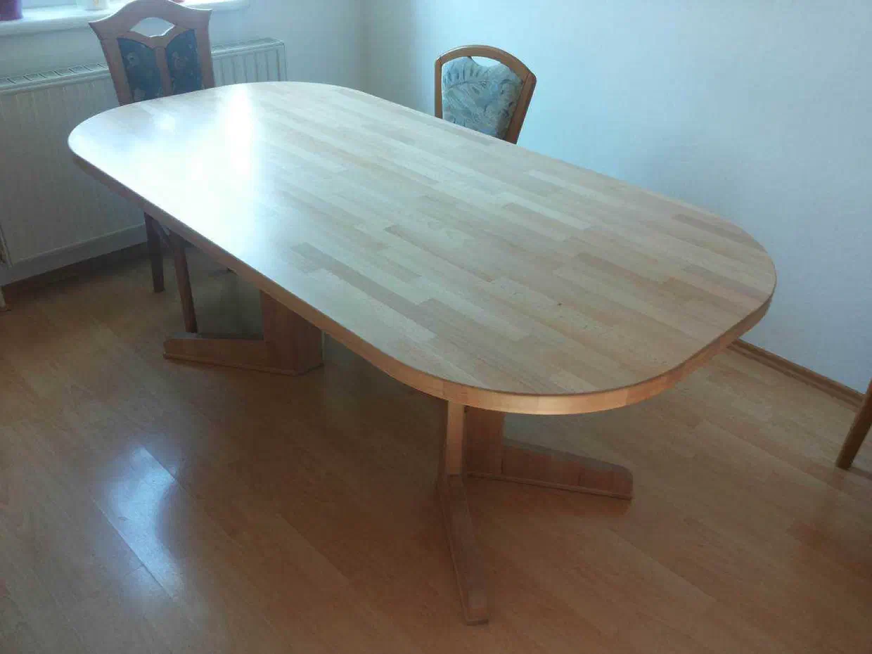 Ovaler Holztisch aus verleimten Holzlamellen mit zwei Kreuzfüßen